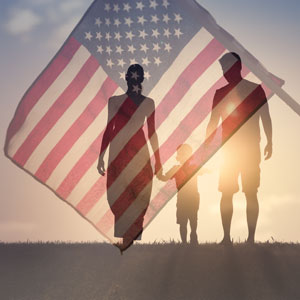 Couple with one child walking together in front of a U.S. flag - Phillip A. Roach Attorney At Law